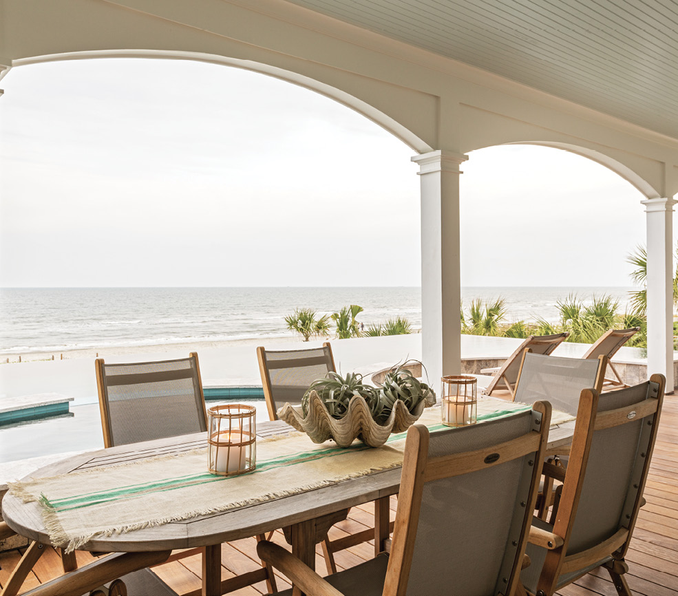 The porch dressed in chaise lounges and a dining set from Teak and Table, provides a shady spot where all generations of their extended families mingle—from the couple’s young nieces to their parents.