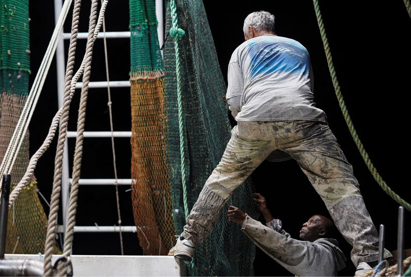 Shawn and Carl work together to ready the nets before the outriggers are lowered for the next trawl.