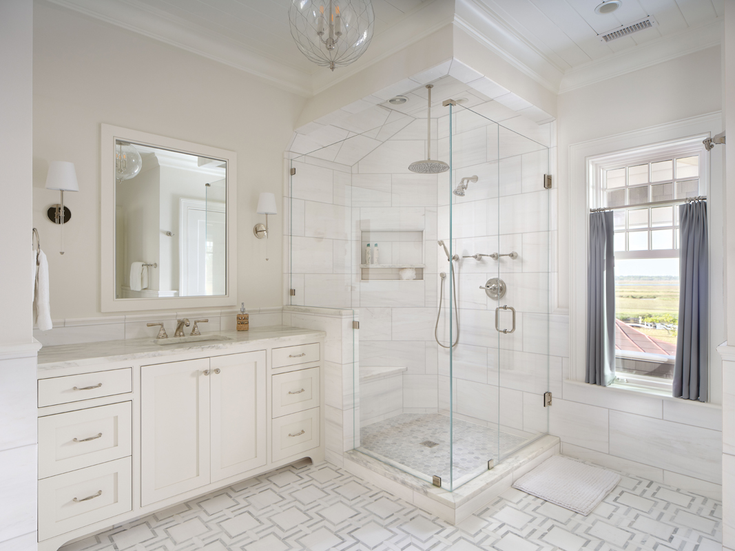 The white, marble-clad bathroom is similarly simple yet stylish and features a striking Remains Lighting chandelier.