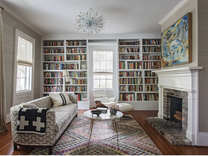 Pattern Play - Designer Jenny Keenan says mixing textiles helps a home feel “more lived-in and not so perfect.” Here, a splashy yellow and blue painting by Indian artist Laxman Pai harmonizes with a graphic pink rug and a patterned vintage sofa.  Location: Old Village, Mount Pleasant (circa 1865, owned by Melanie and Sam Rosen) Issue: January 2017, “A Fresh Take”  Photographer: Julia Lynn