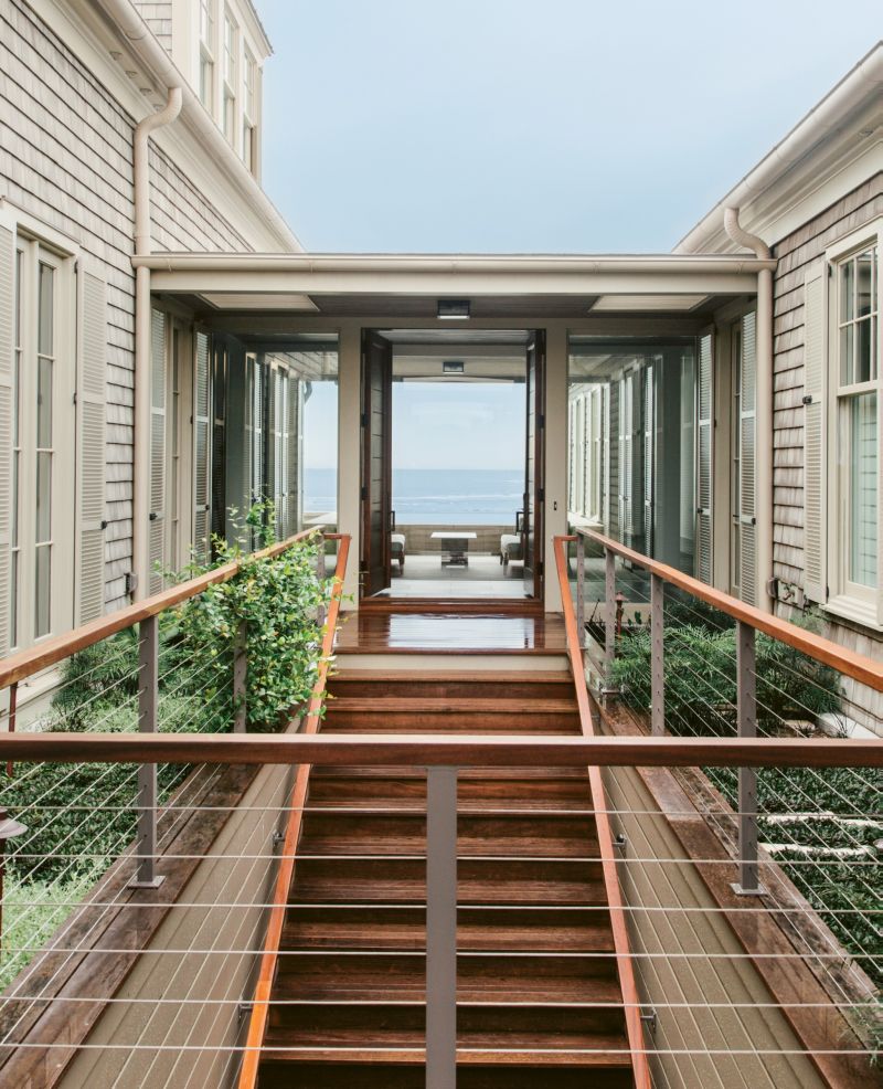 The path to the front door is bordered by garden beds; homeowner Suzanne Fine says these pockets of green are a reference to New York City. “All the plants peeking through are reminiscent of the High Line,” she notes.