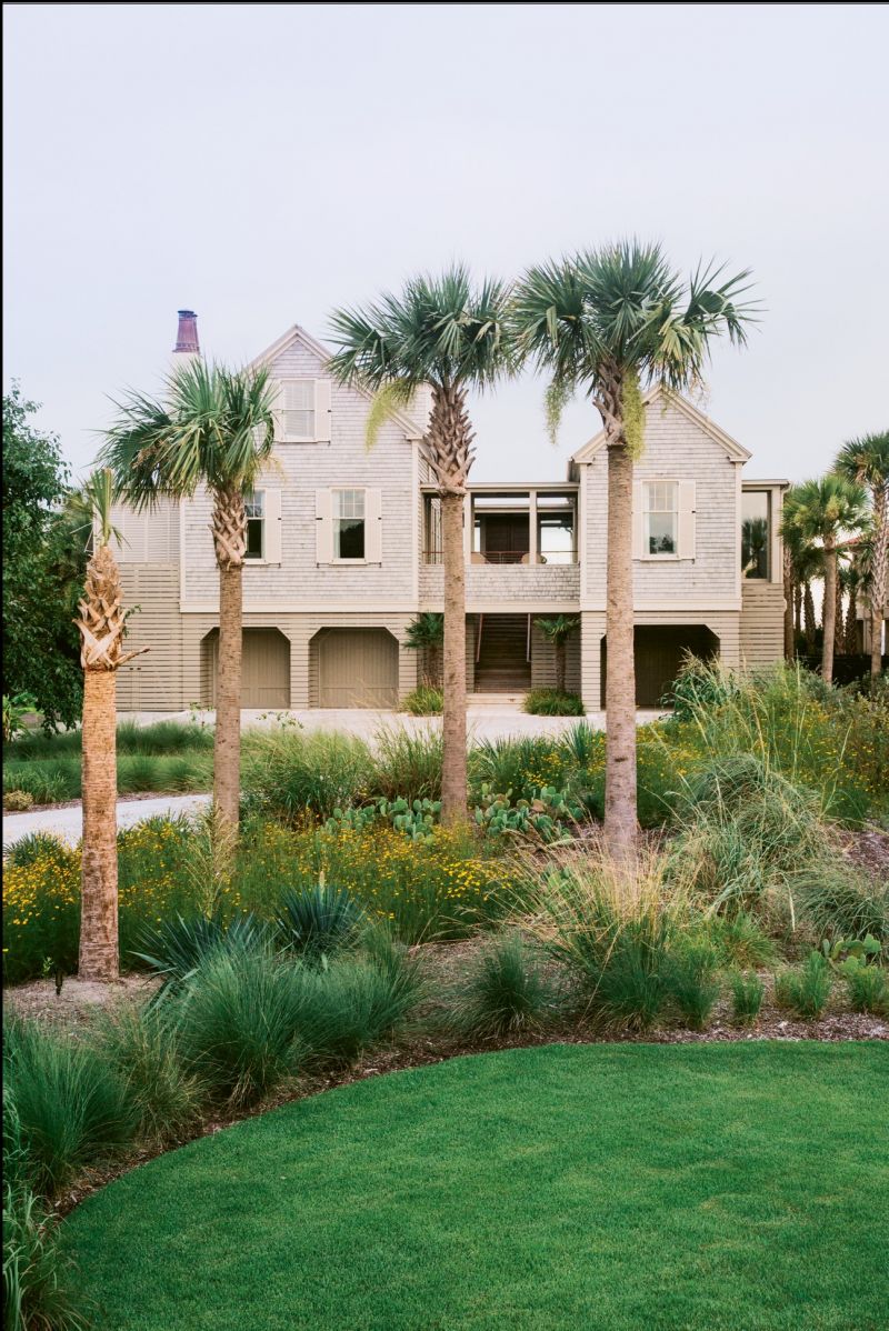 The home’s two traditional cottage forms are united by a glass breezeway and flanked by flat-roofed wings designed to look like modern additions.