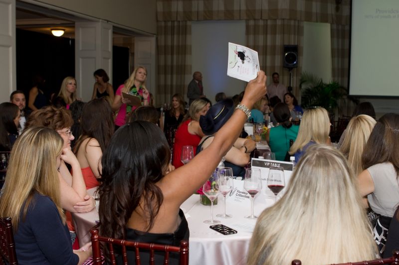 Ladies raised their auction numbers to bid on their favorite items.