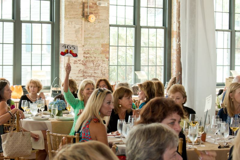 Guests raised paddles featuring Ronald McDonald&#039;s red shoes to bid on their favorite items.