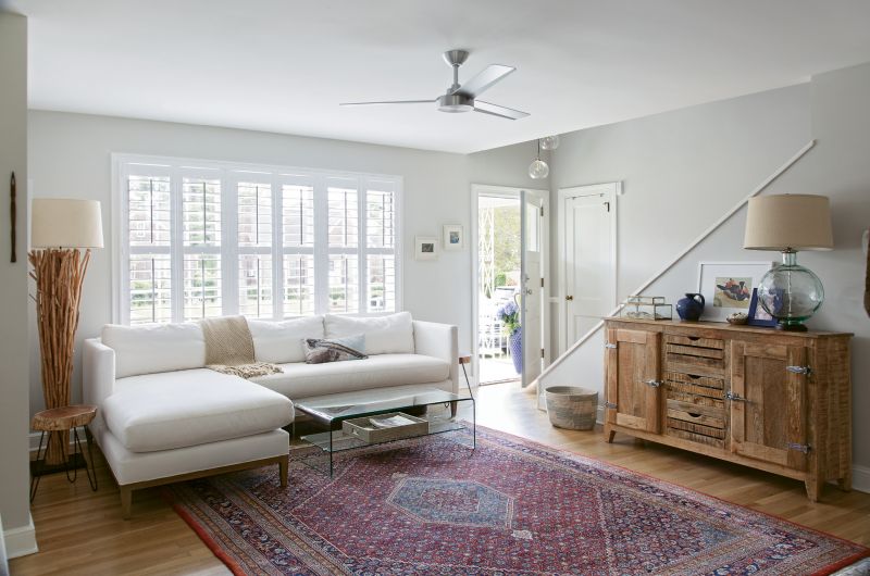 OLD &amp; NEW: The living room is filled with a mix of antiques (the area rug once belonged to Rachel’s grandparents), pieces purchased specifically for the space (like the GDC Home sectional and branch floor lamp from Celadon), and furnishings acquired over time.