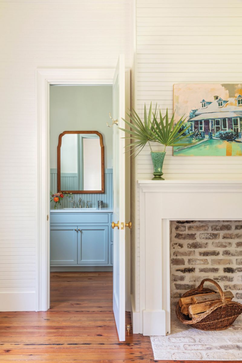 On the opposite side of the central hall, the girls’ playroom features the home’s other original fireplace, highlighted with a white mantel. The room, with its en-suite bath’s beadboard painted in Farrow &amp; Ball “Light Blue,” can double as a guest room.