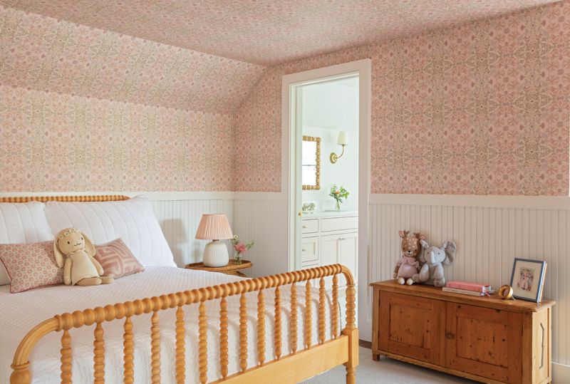 The second floor, formerly a full apartment, has been reworked to accommodate two spacious bedrooms, one for the couple’s eldest daughter and the second as a nursery for their youngest. A playful Helen Prior wallpaper from Fritz Porter rises above restored beadboard in the first room, where a vintage wooden chest pairs with a Jenny Lind bed from Crate &amp; Barrel.