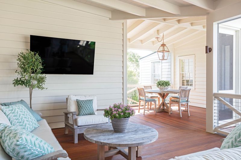 A new screened-in porch and patio in the backyard adds outdoor seating and dining spaces. Aged teak furniture is highlighted by green fabric from Serena Dugan, and a copper lantern sheds a cozy glow on evening gatherings.