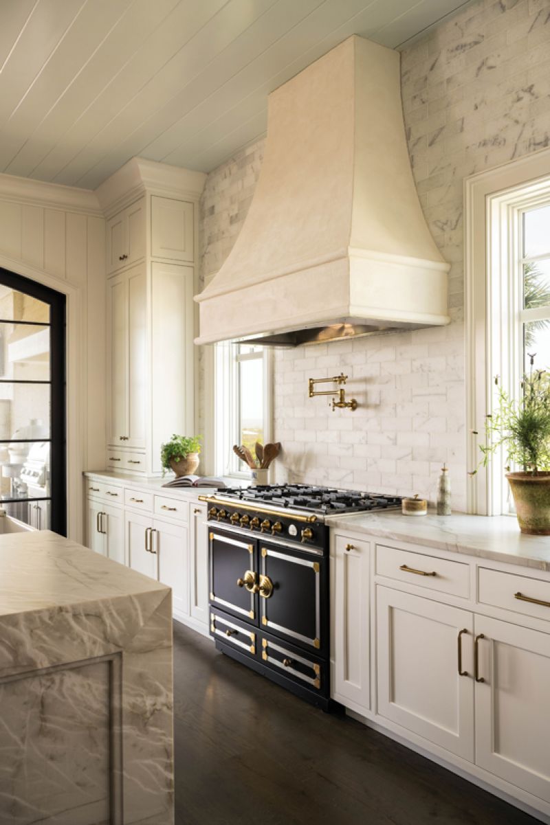 A plaster hood and tiled backsplash highlight the La Cornue range. Quartzite countertops and islands provide ample prep space.