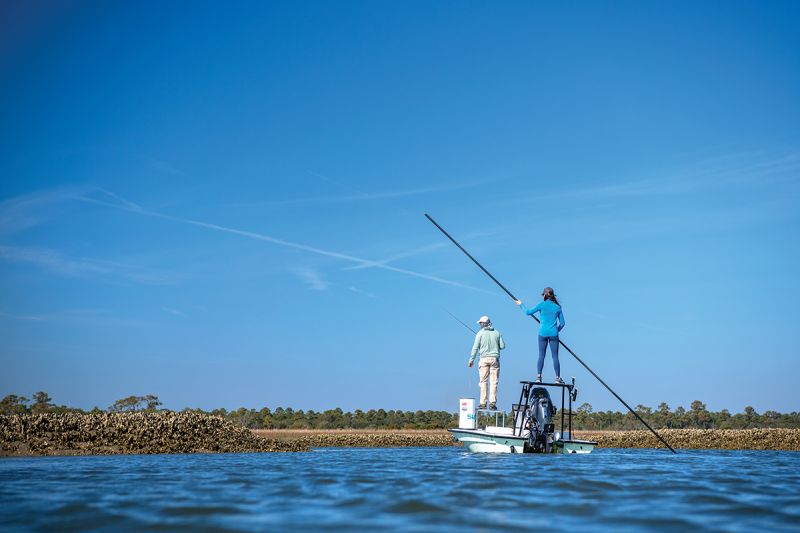 Poling the skiff and casting at low tide.