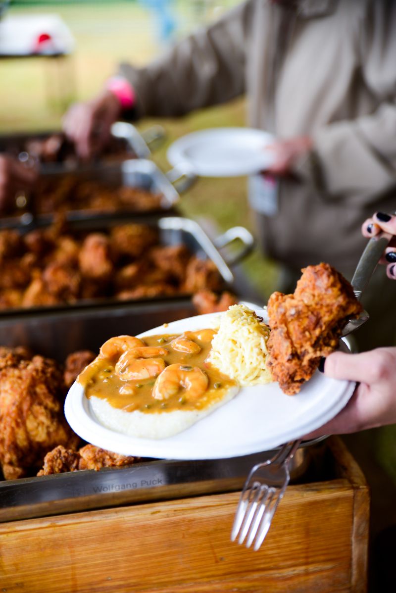 A savory plate of shrimp and grits with fried chicken