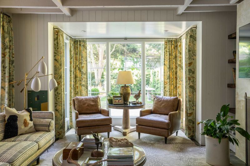 Though bay windows were added to embrace the lush views, structural elements of the 19th-century kitchen house remain, including exposed beams and a wood-burning fireplace.