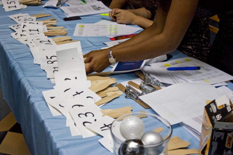 Volunteers distribute auction numbers to guests