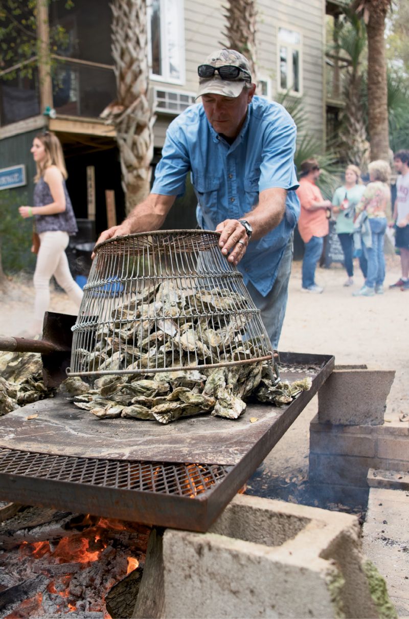 Robbie Cowart shoveled oysters onto  an open-fire grill for hungry guests.