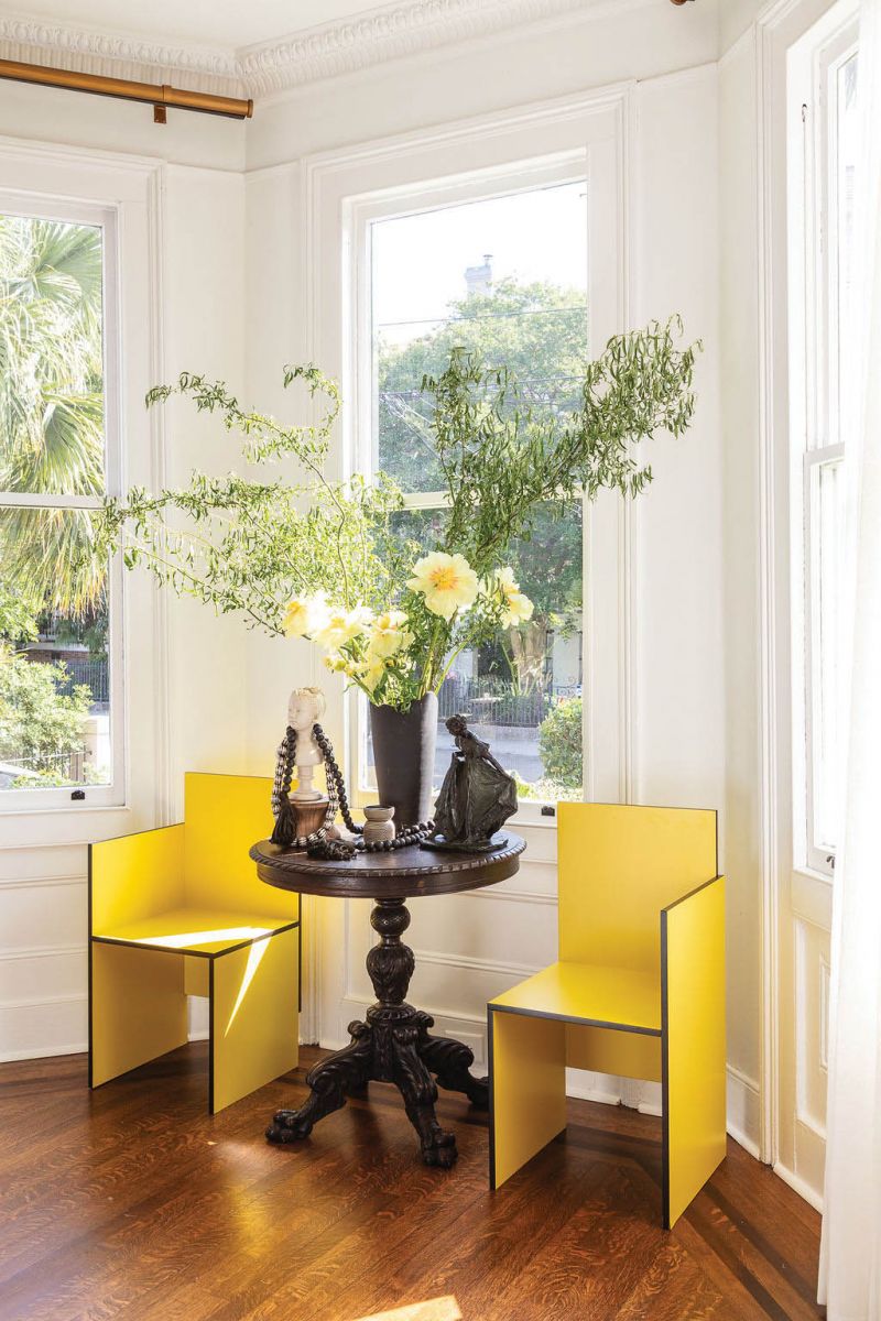 Bright yellow Bauhaus chairs amplify the sunshine streaming in the bay windows.