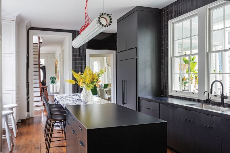 “We knew from the start that we didn’t want an all-white kitchen,” says Phoebe. The sleek space features monochrome Porcelanosa countertops from ARC Interiors, black INAX “Yuki Border” porcelain tiles on the walls, and a Castor “Recycled Tube Light” linear chandelier