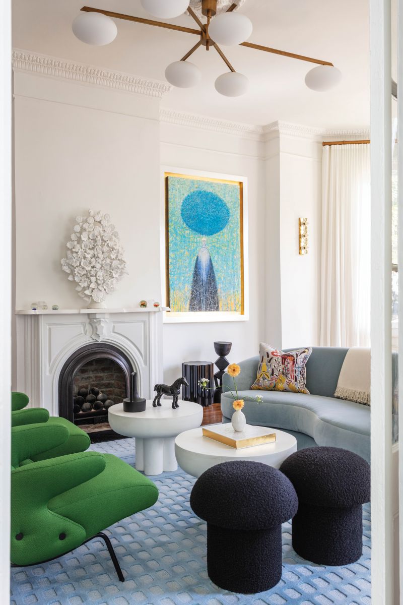 A vintage Angelo Leili pendant sets a contemporary tone for the sophisticated, mod living room, where a Mitchell Gold + Bob Williams sofa, Kelly green Arflex chairs, and Viñas’s award-winning custom rug chime in with color and curve.