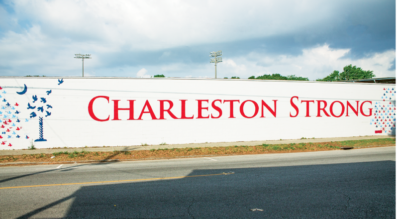 Last fall, Citadel cadets painted the message calling for community strength and solidarity, alongside Shuler’s palmetto, on the old baseball stadium wall. The public was invited to paint the doves, the first of which were stenciled by then-Mayor Joe Riley and State Senator Marlon Kimpson in a special ceremony. Photograph by Amy Luke