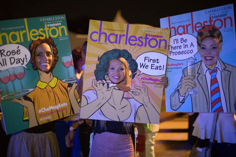 Party-goers smile for a photo with Charleston magazine&#039;s pop art covers.