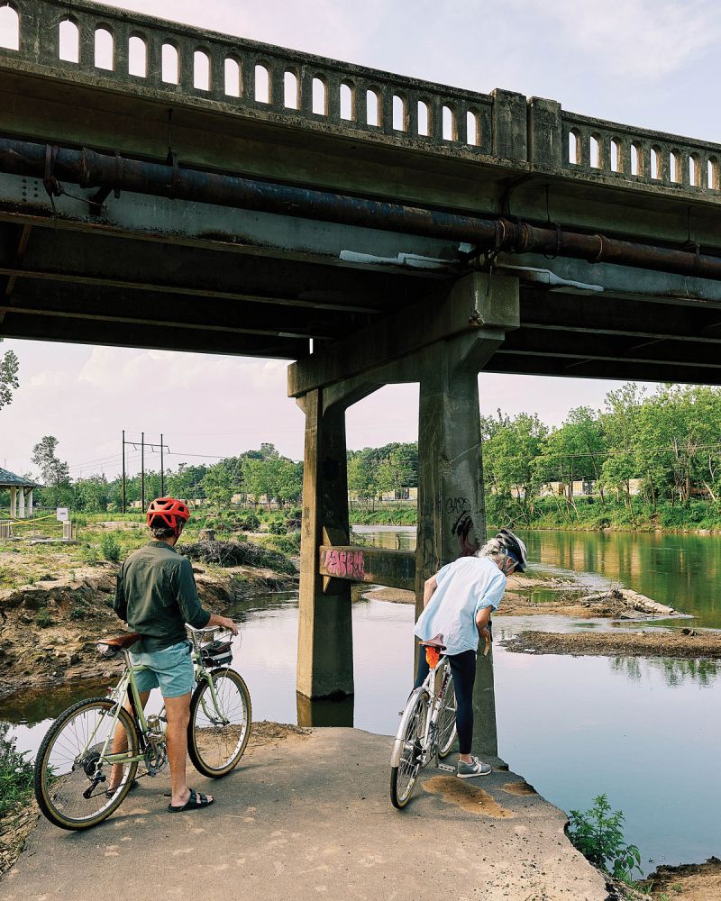 Bicyclists and runners still flock to the French Broad River Greenway, where Helene’s destructive flooding washed away a section of the trail near the Amboy Bridge.