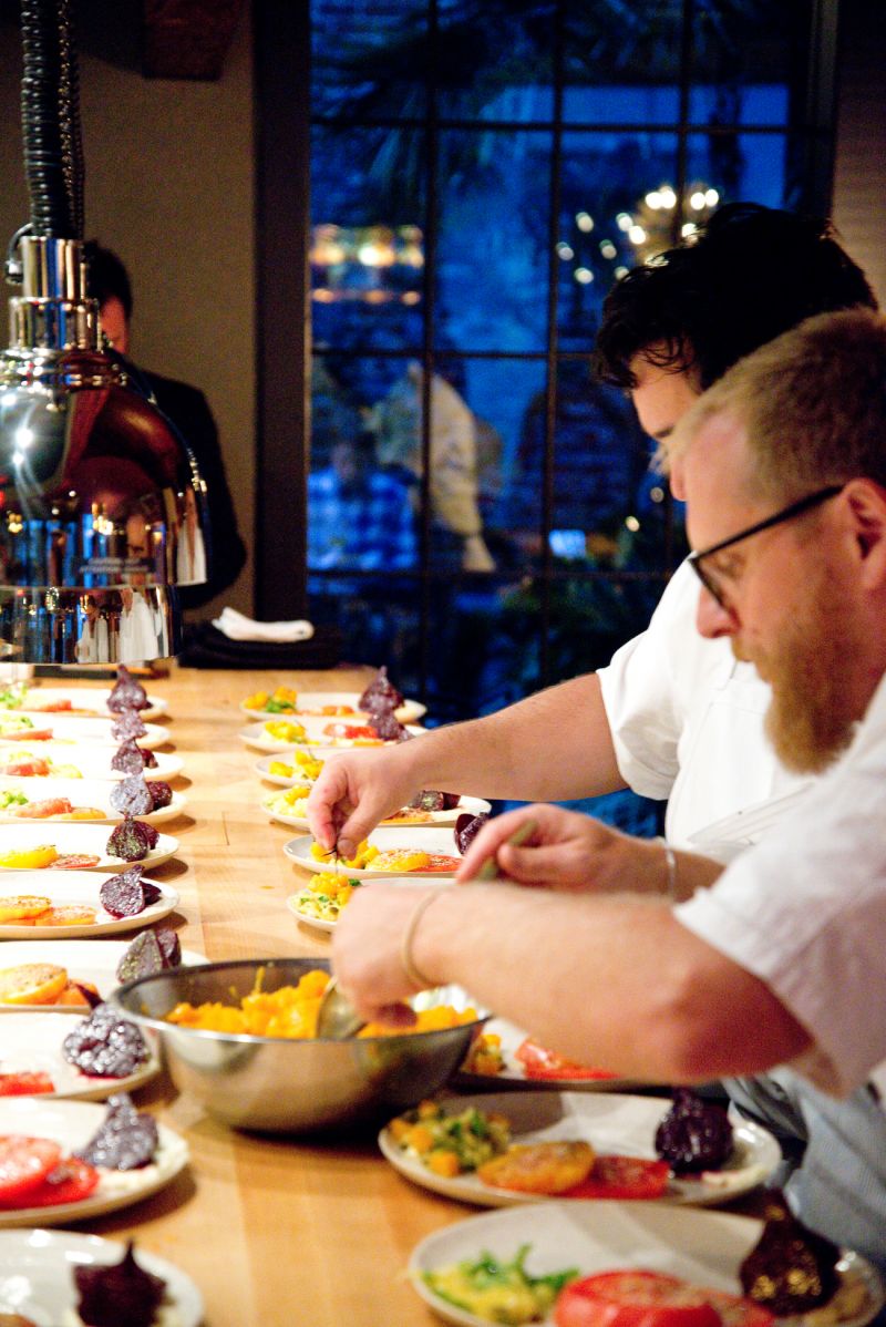 Chefs Jacques Larson and Jason Stanhope put finishing touches on the first course, a salad of early fall vegetables.